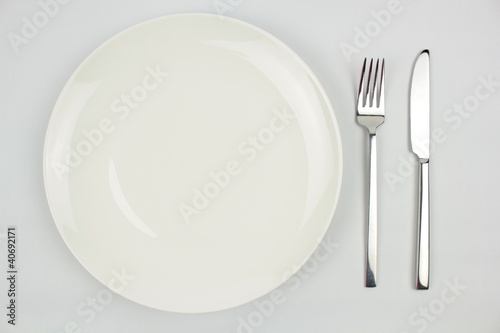 Knife, fork and plate isolated on white background