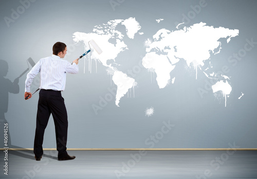 Businessman with paint brush and world map