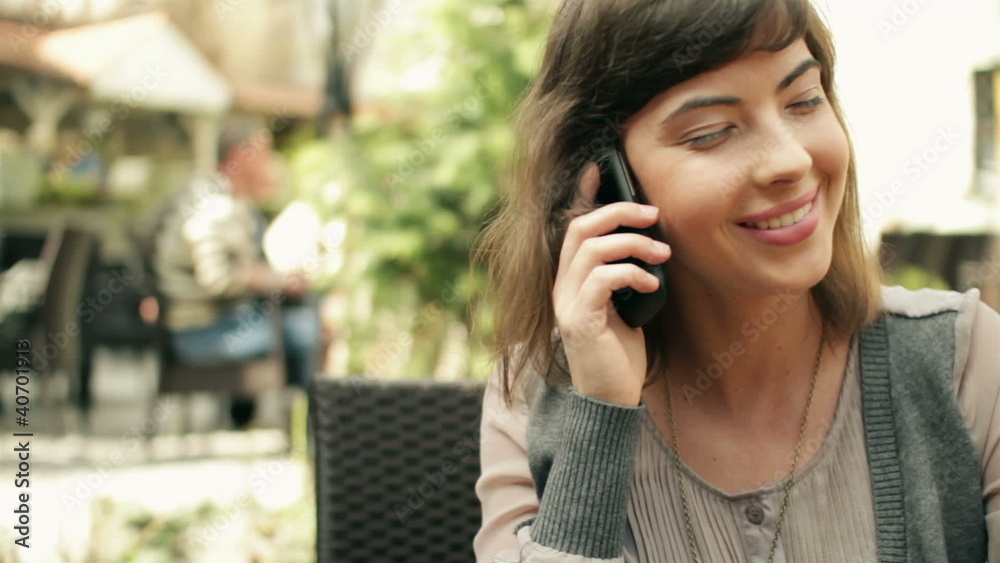 Woman drinking juice and talking on cellphone, steadicam shot Woman drinking juice and talking on cellphone, steadicam shot