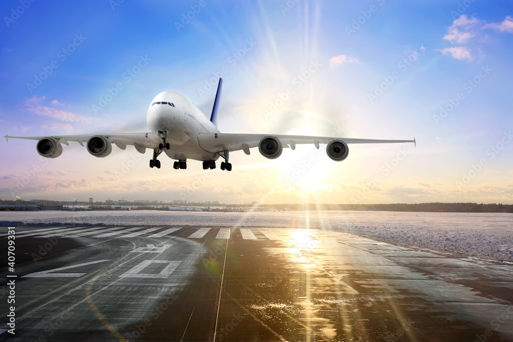 Fototapeta premium Pasażerski samolot lądujący na pasie startowym na lotnisku. Wieczór