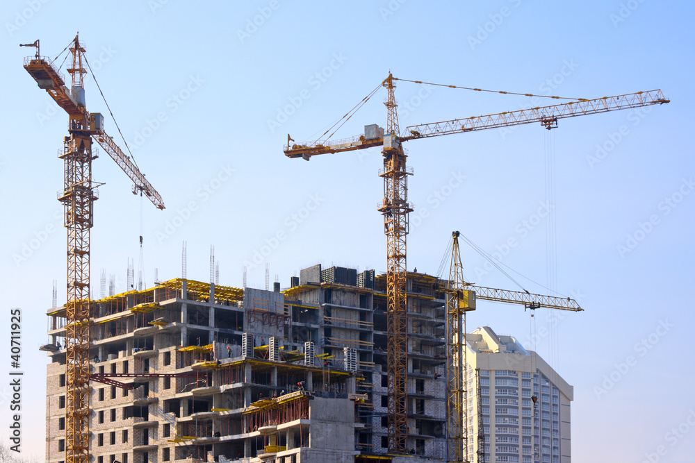 Building cranes and under construction building Building cranes and under construction building