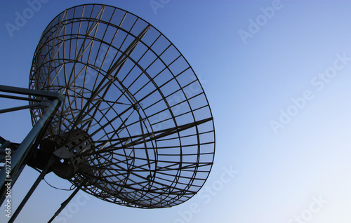 satellite dish silhoette on blue sky background.
