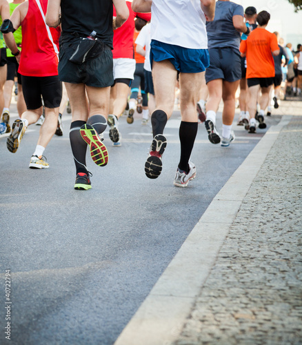 People running in city marathon on street