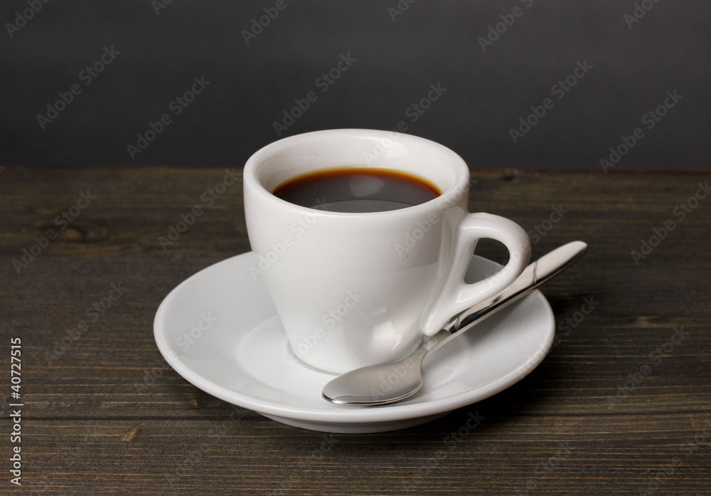 Coffee cup on wooden table on grey background