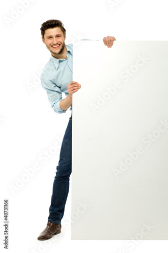 Φωτογραφία Man peeping from behind the blank board