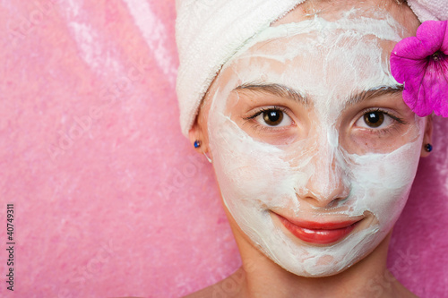Cute young girl with a facial mask at a spa