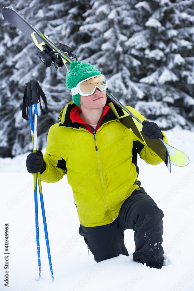 Young Man On Ski Holiday In Mountains