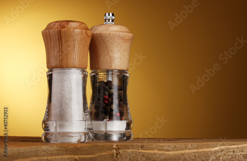 Salt and pepper mills on yellow photo