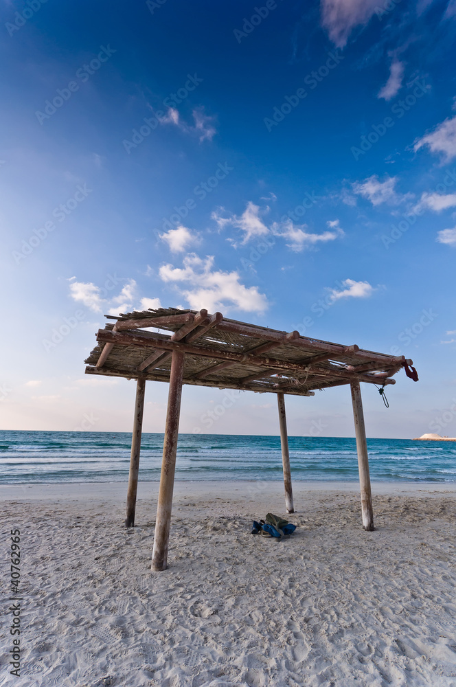 wooden canopy on the sandy beach and blue sky