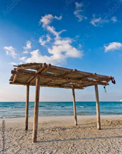 Fototapeta Naklejka Na Ścianę i Meble -  wooden canopy on the sandy beach and blue sky