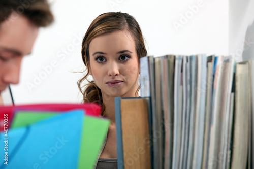 Woman gazing at a man in a library photo