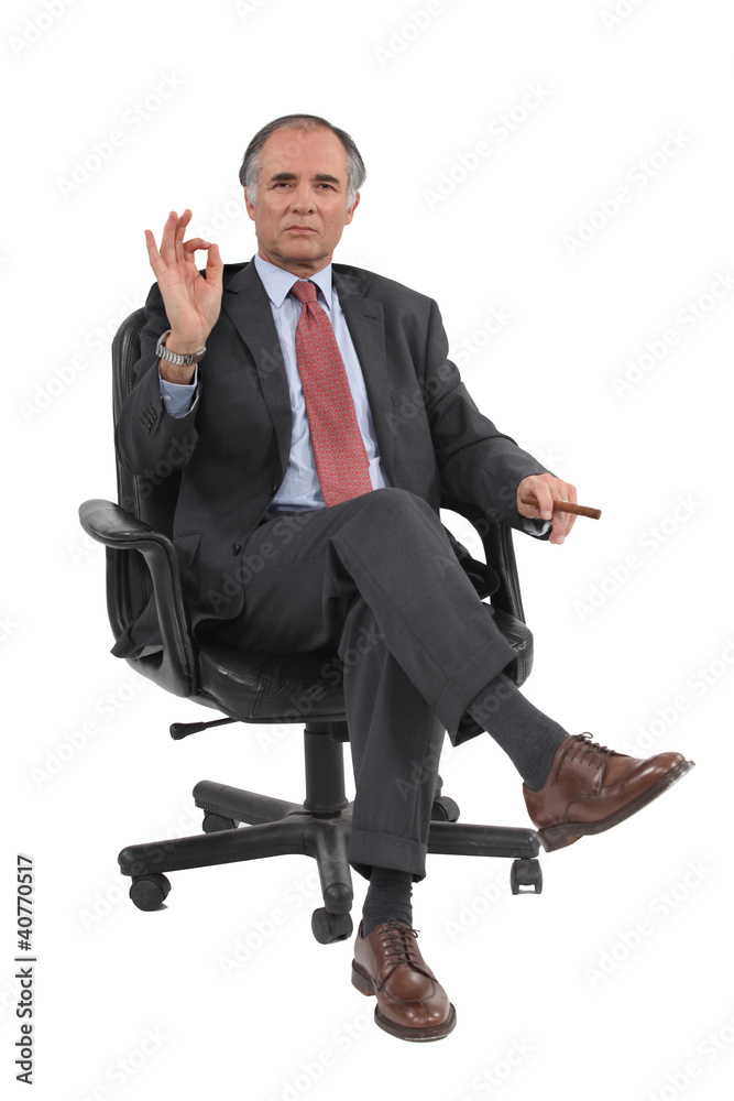Senior businessman sat giving the OK gesture Senior businessman sat giving the OK gesture