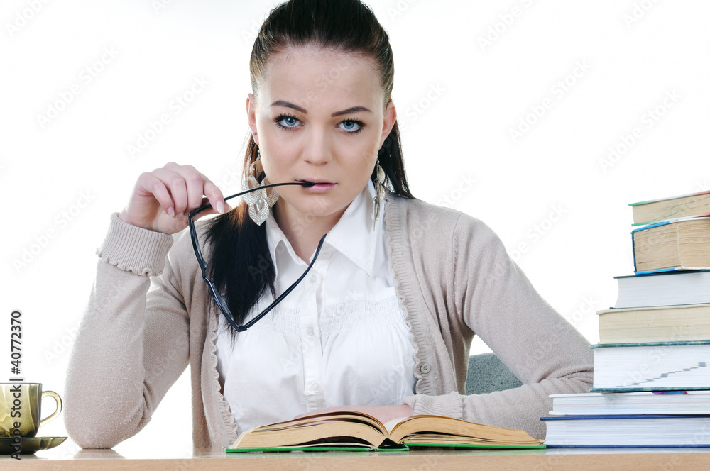 Student girl reads a book at the table Student girl reads a book at the table