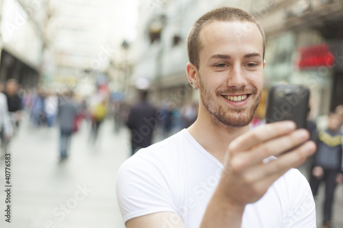 Young Man with cell phone walking