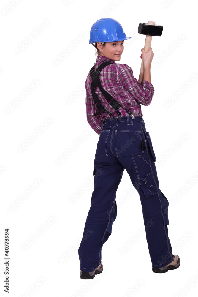 A female construction worker holding a sledgehammer. A female construction worker holding a sledgehammer.