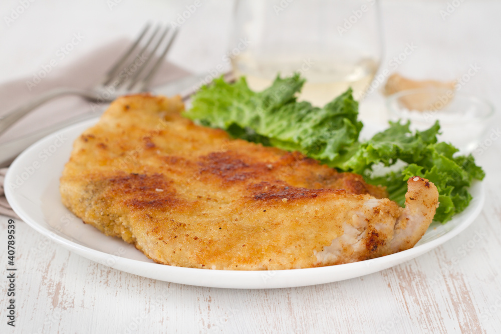 fried turkey with salad on the white plate