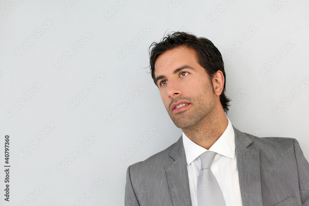 Businessman standing on white wall Businessman standing on white wall
