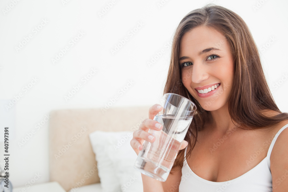 Woman smiling as she holds a glass of water, Woman smiling as she holds a glass of water,