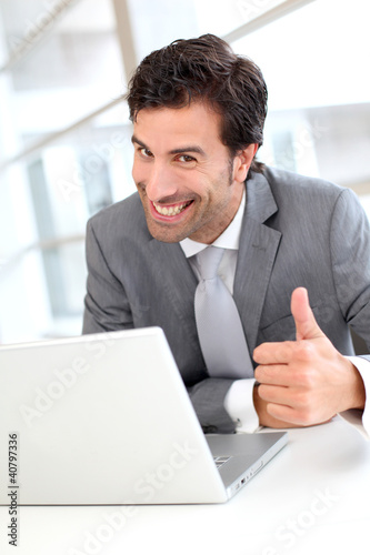 Portrait of cheerful businessman showng thumb up