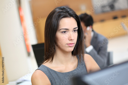 Woman working in office in front of desktop computer