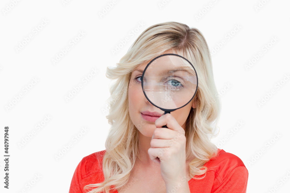Fair-haired woman looking through a magnifying glass Fair-haired woman looking through a magnifying glass