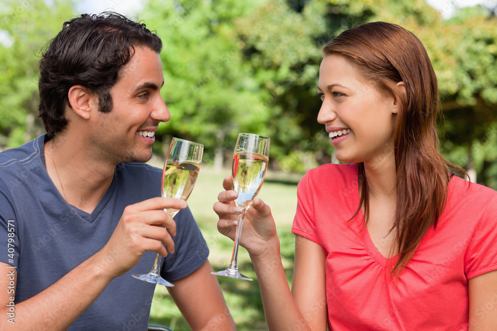 Two friends looking at each other while they are holding glasses Two friends looking at each other while they are holding glasses