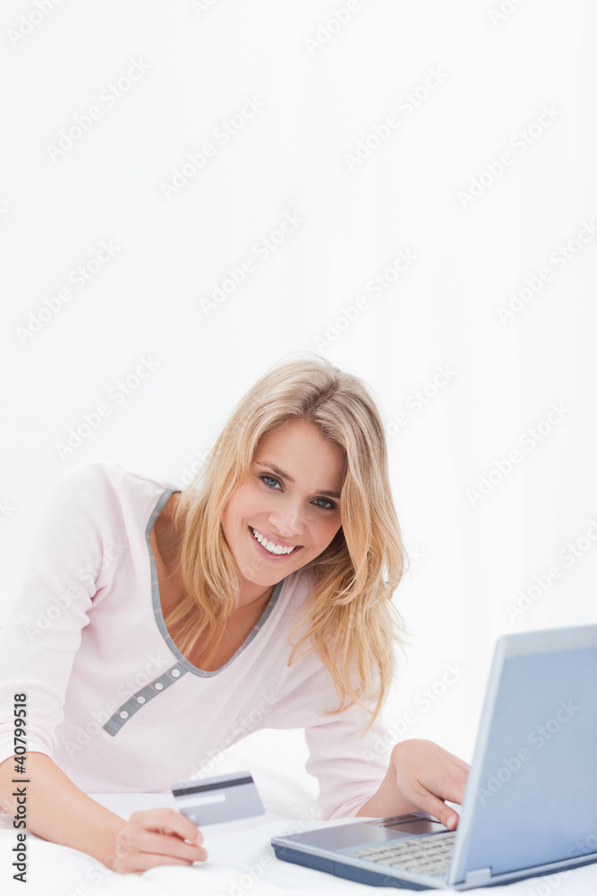 Woman looking forward and smiling as she orders online Woman looking forward and smiling as she orders online