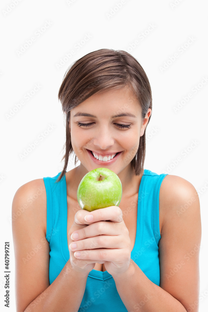 Smiling teenager looking at a green apple placed on her hands cr Smiling teenager looking at a green apple placed on her hands cr