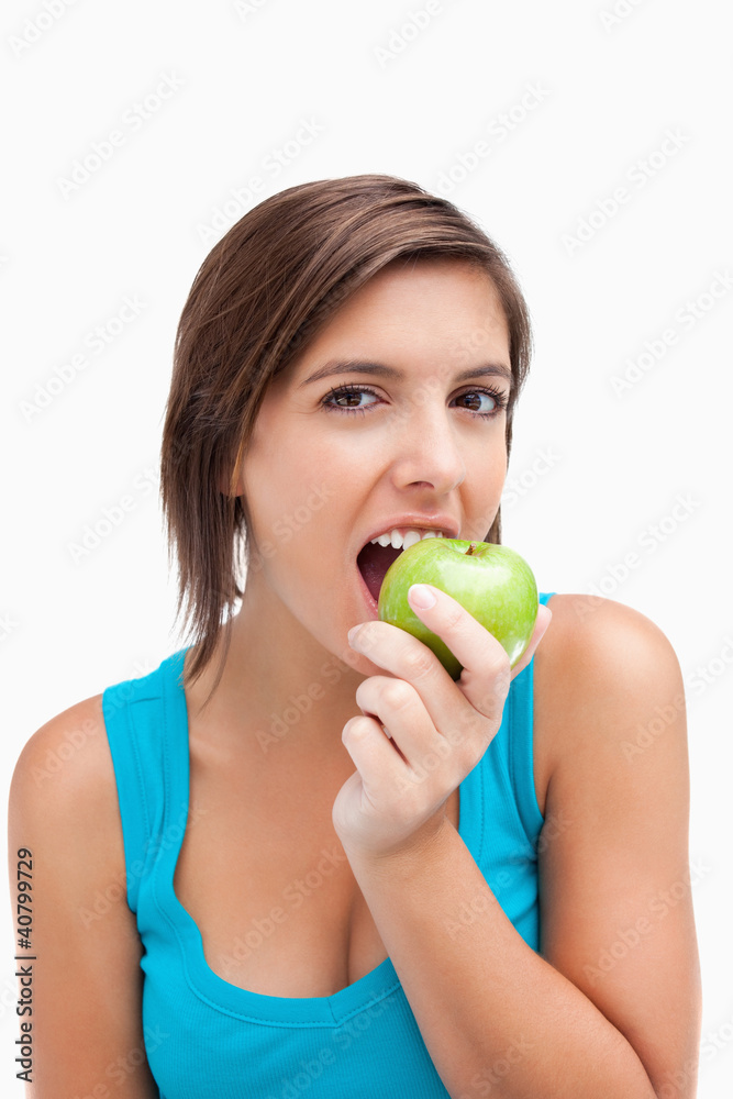 Attractive teenager eating a green apple Attractive teenager eating a green apple
