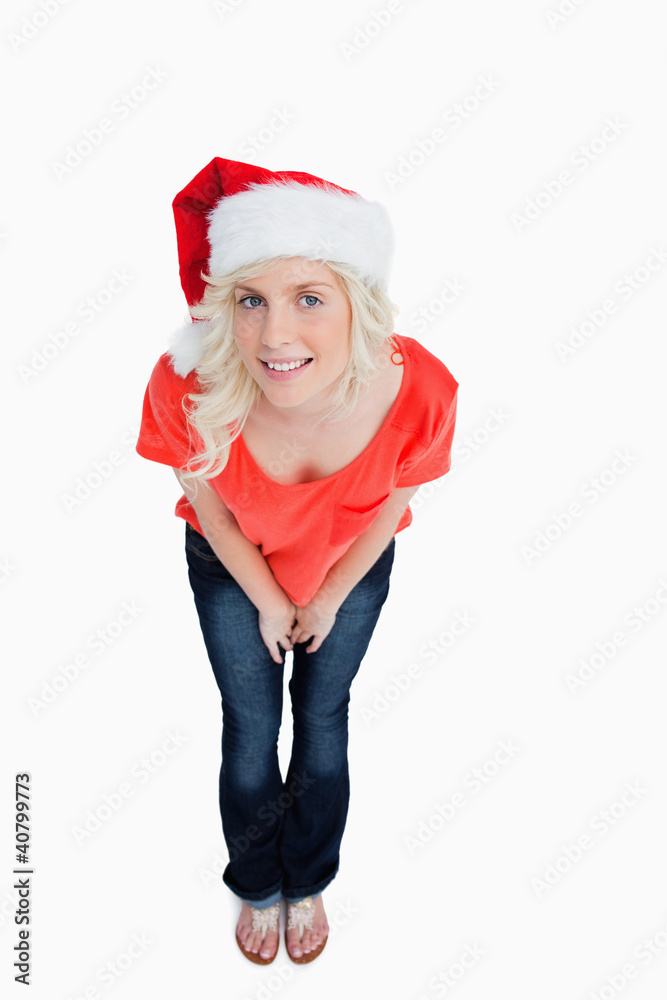 Fair-haired woman wearing the Santa Claus hat while leaning forw Fair-haired woman wearing the Santa Claus hat while leaning forw
