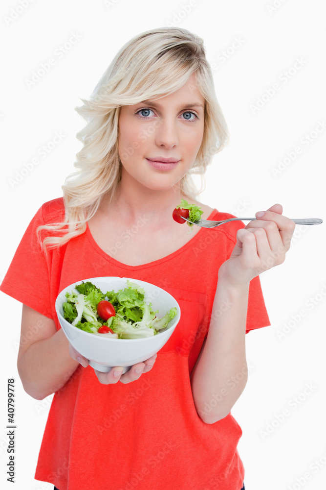 Young blonde woman eating a vegetable salad Young blonde woman eating a vegetable salad