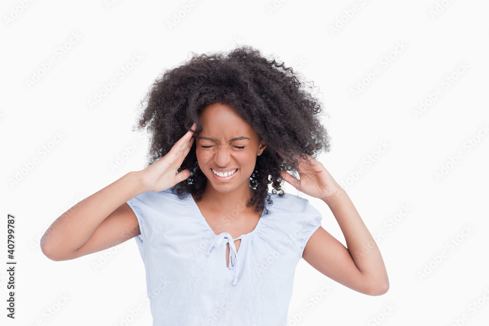Young woman touching her temples while being angry Young woman touching her temples while being angry