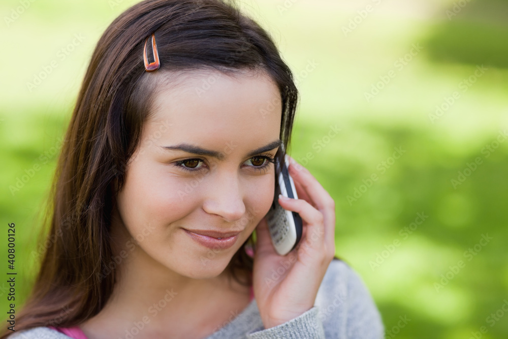 Young relaxed girl talking on the phone in a park Young relaxed girl talking on the phone in a park