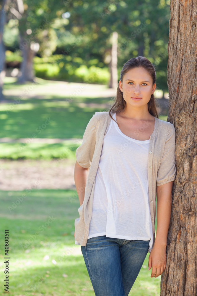 Woman resting against a tree