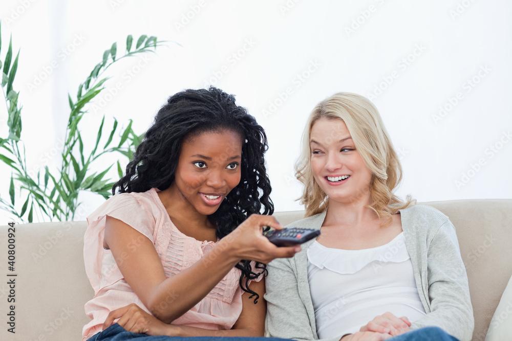 A woman is smiling at her friend who is holding a television rem A woman is smiling at her friend who is holding a television rem