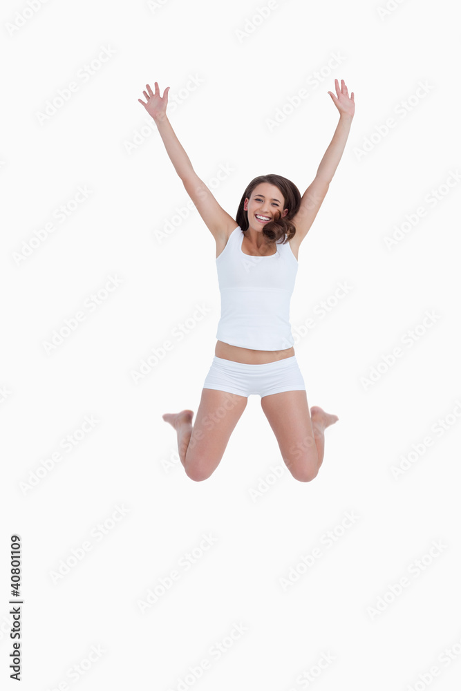 Smiling woman jumping with arms raised
