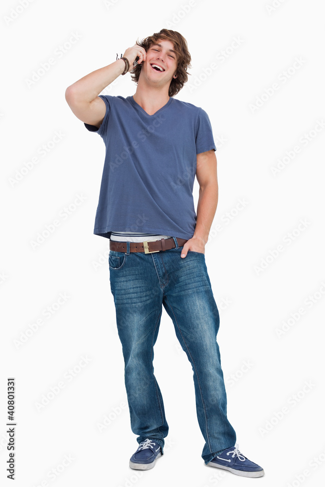 Standing male student laughing while calling Standing male student laughing while calling