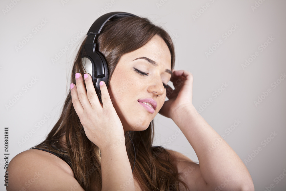 Beautiful cheerful young woman enjoying music Beautiful cheerful young woman enjoying music