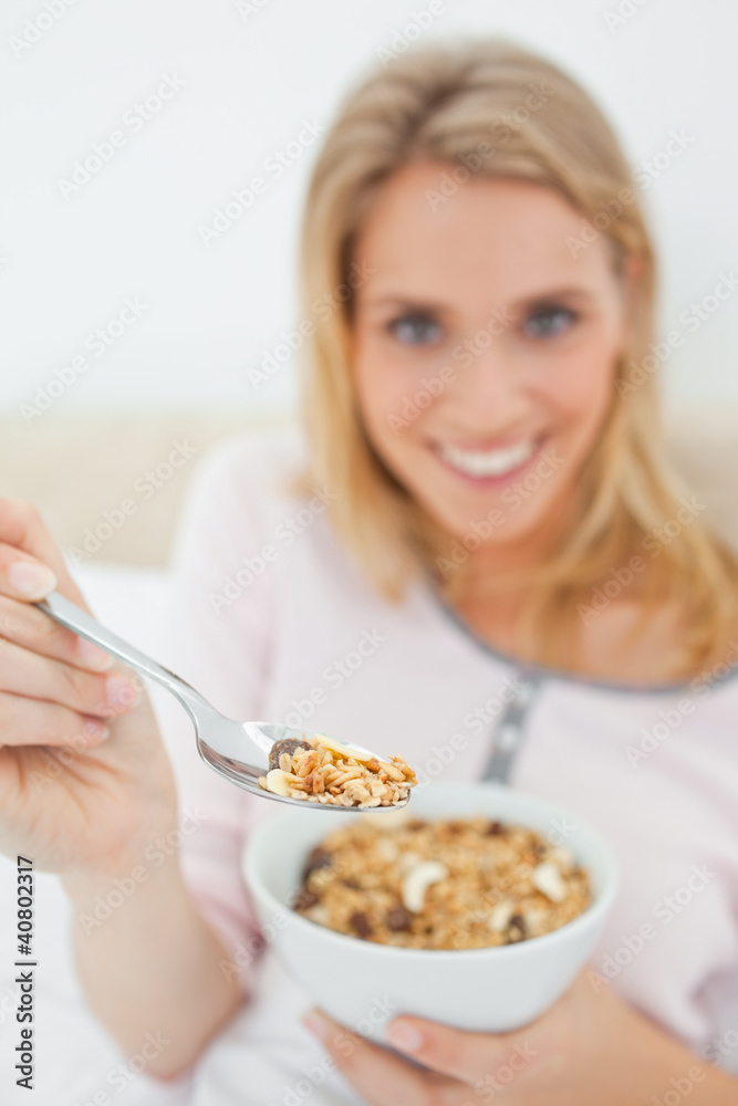 Focus shot, woman offering a spoon of cereal, focused on the spo Focus shot, woman offering a spoon of cereal, focused on the spo
