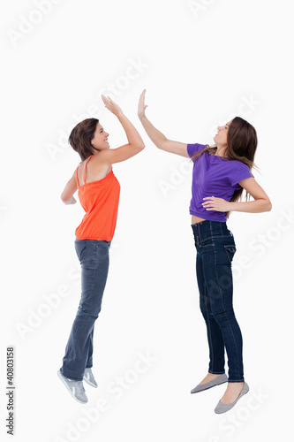 Teenagers jumping while giving each other a high-five