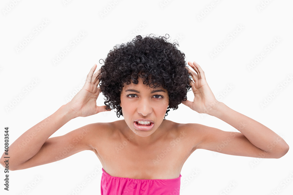 Young woman placing her hands beside her ears Young woman placing her hands beside her ears