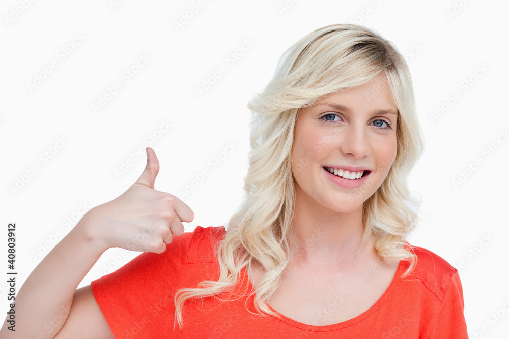 Smiling young blonde woman putting her thumbs up in agreement Smiling young blonde woman putting her thumbs up in agreement
