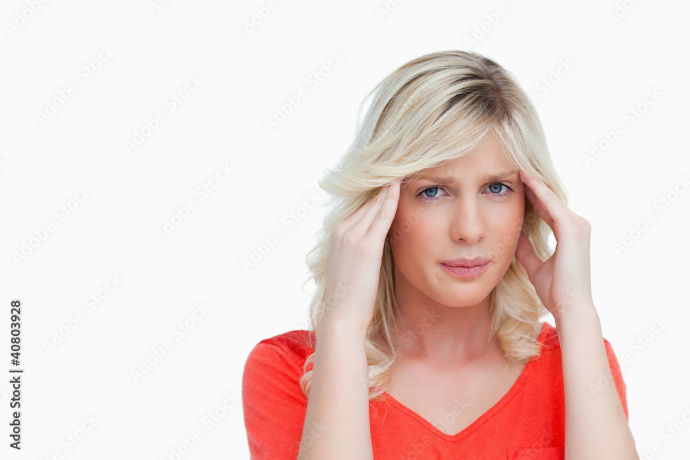 Young woman placing her hands on her temples while suffering fro Young woman placing her hands on her temples while suffering fro
