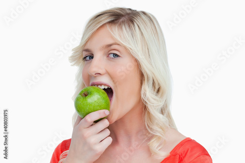 Attractive woman eating a delicious green apple