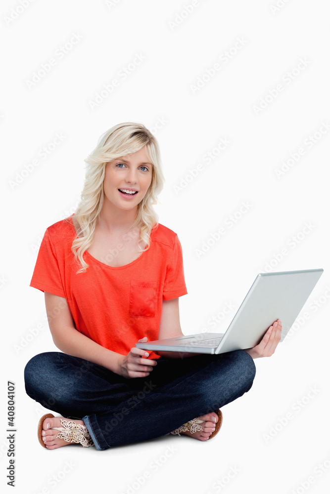 Young woman sitting cross-legged holding her laptop Young woman sitting cross-legged holding her laptop