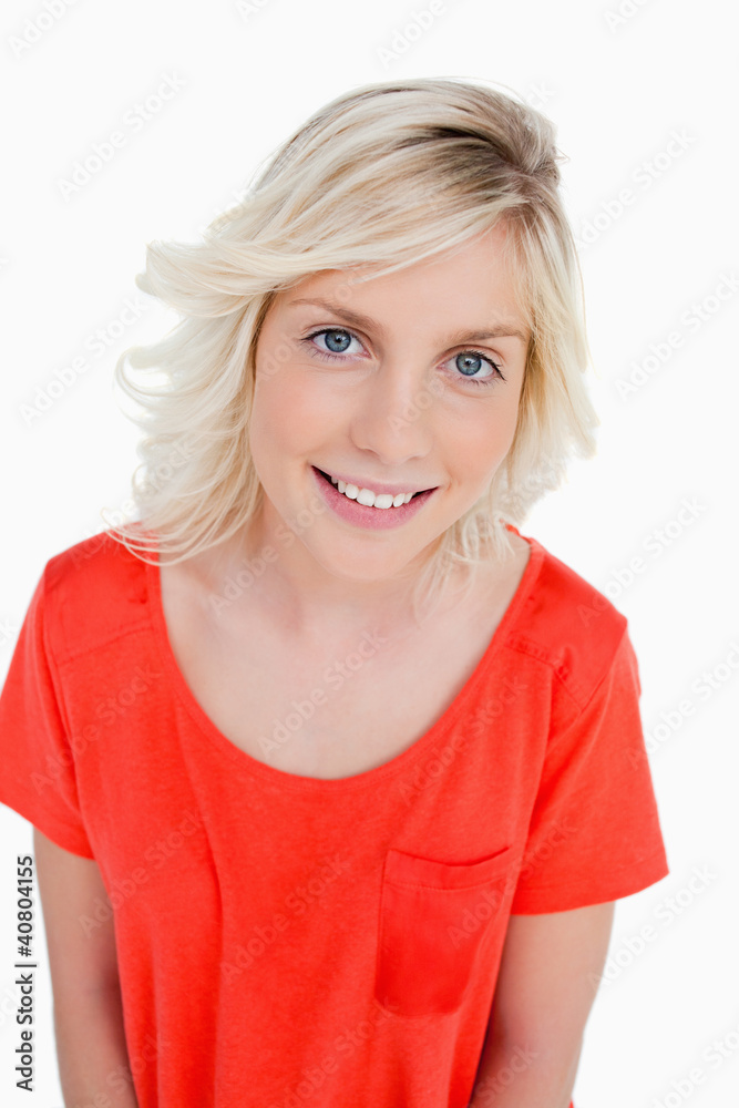 Smiling fair-haired teenager standing upright while looking at t Smiling fair-haired teenager standing upright while looking at t