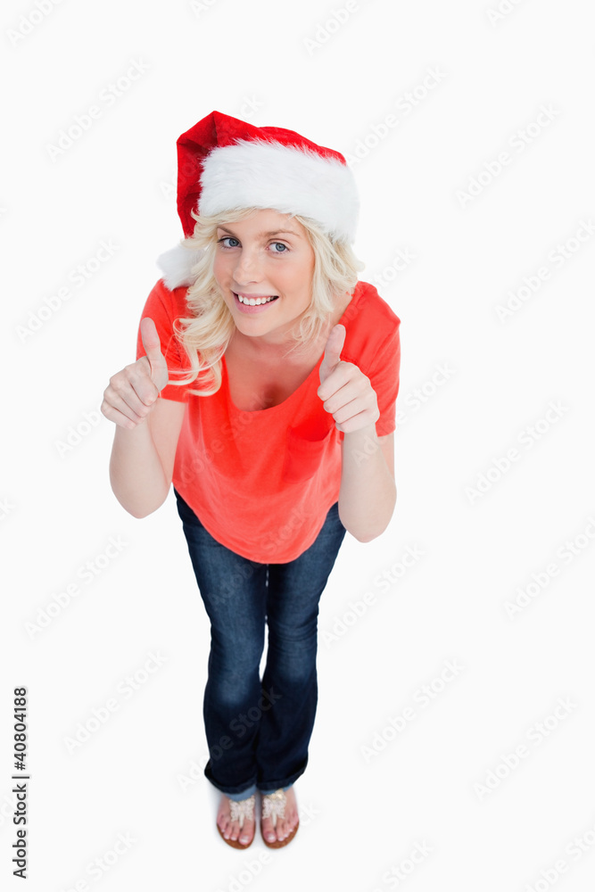 Fair-haired woman putting her thumbs up while wearing Christmas Fair-haired woman putting her thumbs up while wearing Christmas