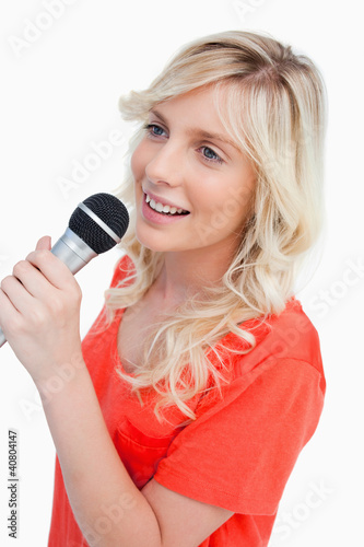 Smiling woman singing with a microphone