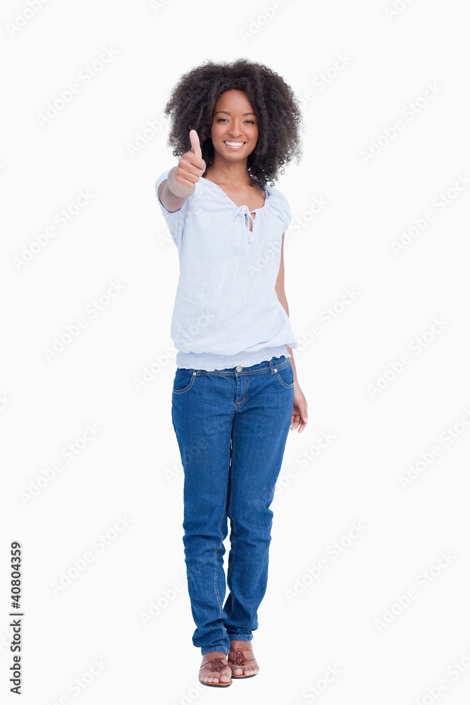 Young woman showing a great smile while placing her thumbs up Young woman showing a great smile while placing her thumbs up