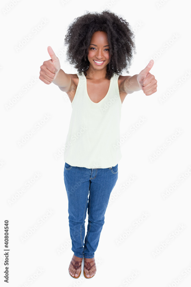 Young relaxed woman standing upright with her thumbs up Young relaxed woman standing upright with her thumbs up